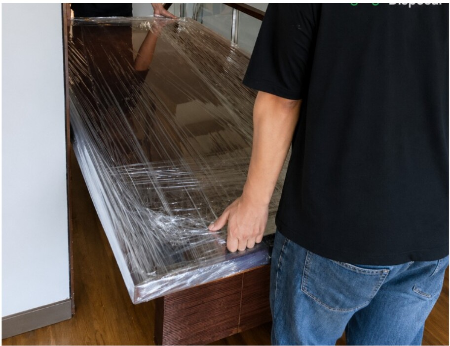 Crew wrapping furniture before move